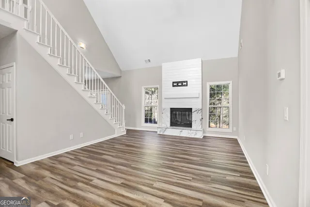 a view of empty room with fireplace and wooden floor