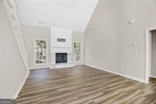 a view of a livingroom with wooden floor and a fireplace
