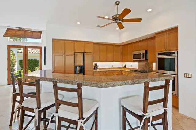 a view of a kitchen with granite countertop cabinets and chairs