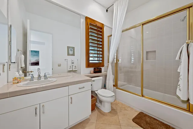 a spacious bathroom with a shower sink and mirror