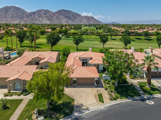 an aerial view of a house with a garden and lake view