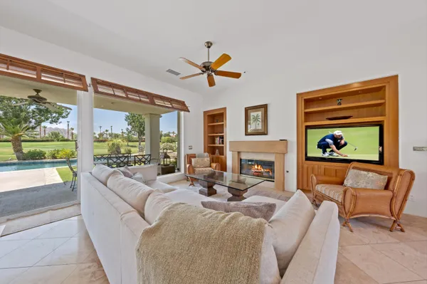 a living room with fireplace furniture and a large window