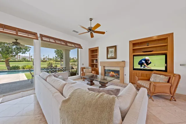 a living room with fireplace furniture and a large window