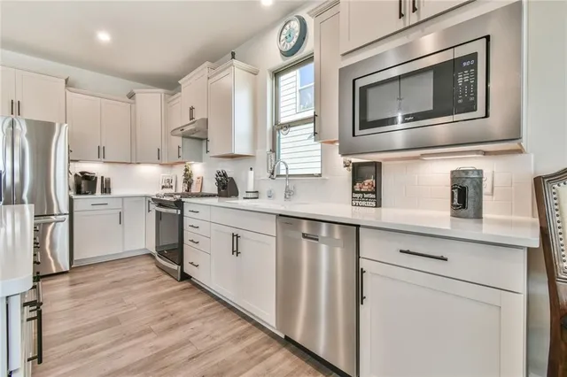 a bathroom with a sink a toilet a mirror and shower
