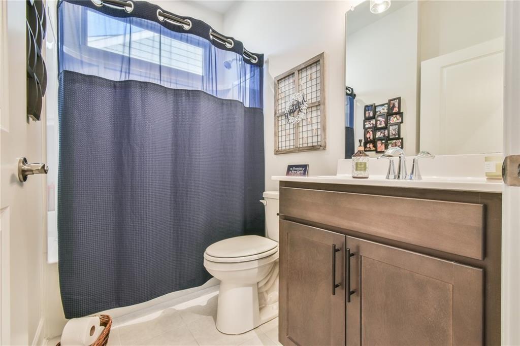 5051 Adler Court Hoschton, GA 30548 - Photo 22 of 41 a bathroom with a sink a toilet a mirror and shower