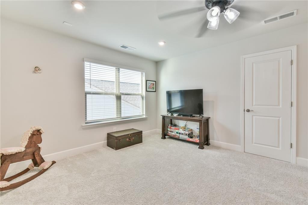 5051 Adler Court Hoschton, GA 30548 - Photo 24 of 41 a living room with furniture and a flat screen tv