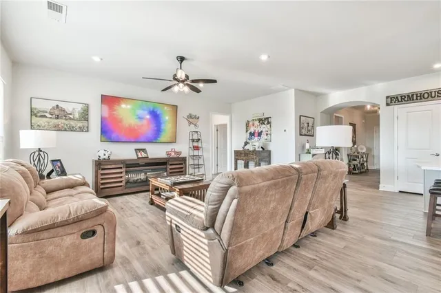 a kitchen with stainless steel appliances a stove a sink dishwasher a refrigerator white cabinets and wooden floor next to a window