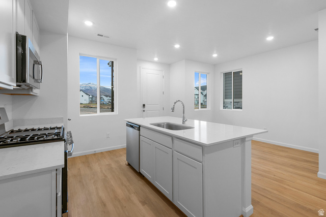 1302 East 1670th North, Unit 908 Payson, UT 84651 - Photo 4 of 21 Kitchen featuring stainless steel appliances, white cabinets, light stone countertops, an island with sink, and recessed lighting