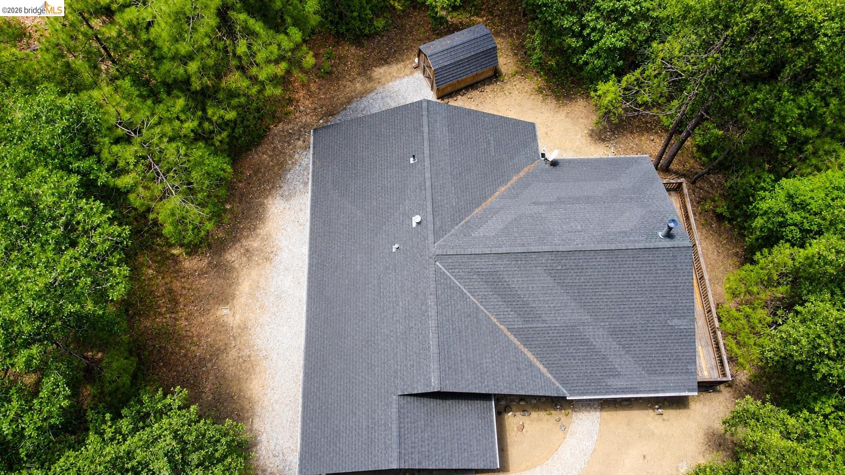 21181 Phoenix Lake Road Sonora, CA 95370 - Photo 5 of 34 Asphalt shingle roofing with multiple peaks and valleys, surrounded by dense natural foliage