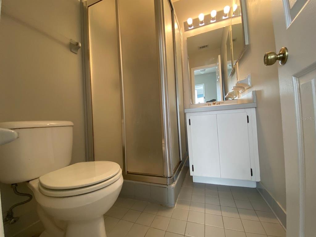 2858 Southwest 39th Avenue Gainesville, FL 32608 - Photo 11 of 12 a bathroom with a granite countertop toilet a sink a mirror and shower