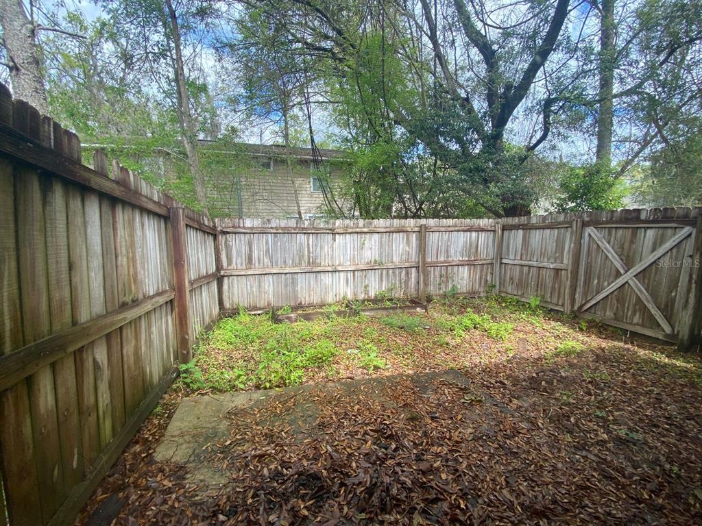 2858 Southwest 39th Avenue Gainesville, FL 32608 - Photo 12 of 12 a view of backyard with wooden fence and a large tree