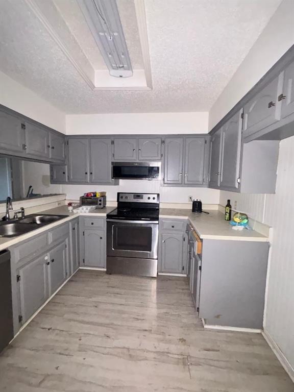 1107 Rimcrest Drive Arlington, TX 76017 - Photo 7 of 13 a kitchen with stove a sink and white cabinets