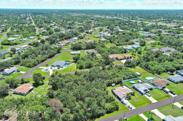an aerial view of residential houses with outdoor space and trees
