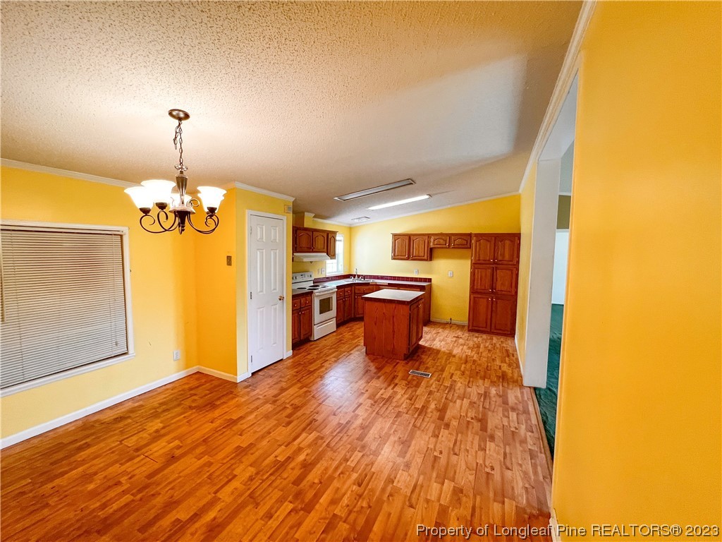 74 Decker Road St. Pauls, NC 28384 - Photo 27 of 46 a bedroom with a bed and a chandelier