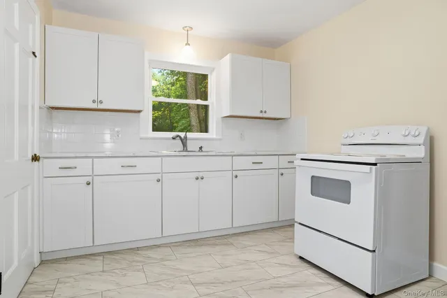 a kitchen with white cabinets and white appliances