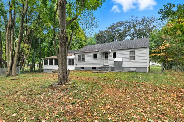 a house that has a tree in front of a house