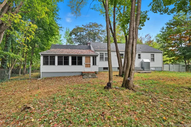 a white house that has a tree in front of it