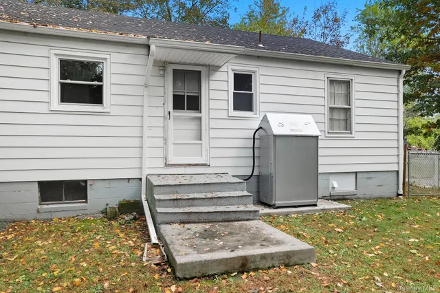 a view of a house with backyard and wooden fence