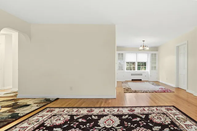 a view of a bedroom with wooden floor and a window