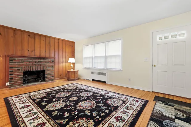 a living room with a rug and a fireplace
