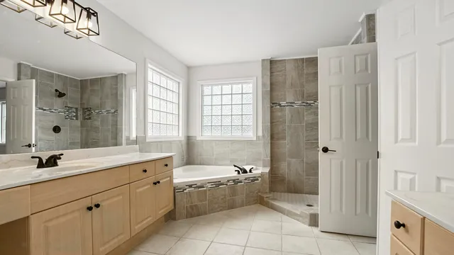 a bathroom with a double vanity sink toilet mirror and bathtub