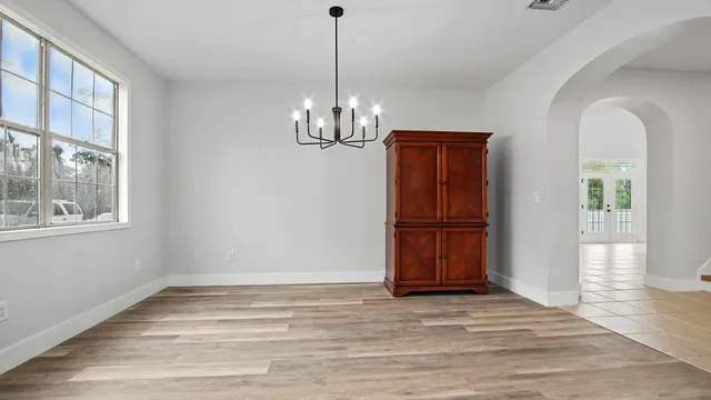 a view of empty room with wooden floor and window