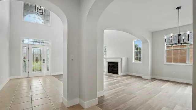 a view of a hallway with wooden floor and a living room