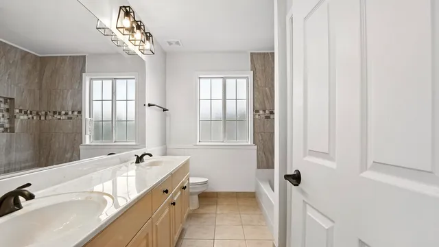 a spacious bathroom with a tub sink and mirror