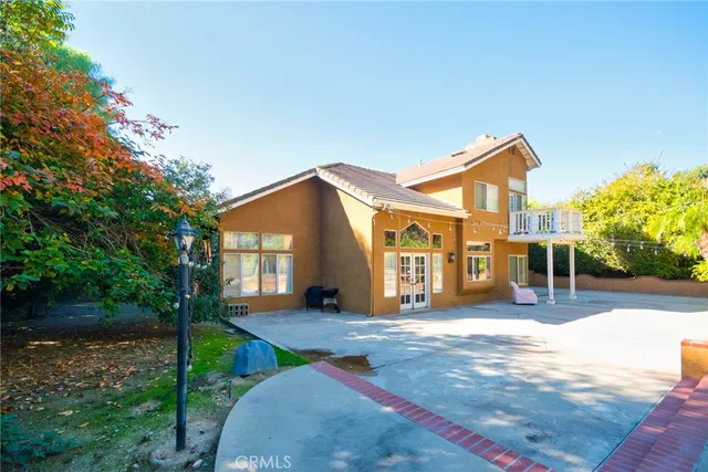 a front view of a house with a yard and potted plants
