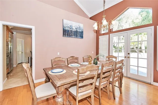a view of a dining room with furniture a chandelier and wooden floor