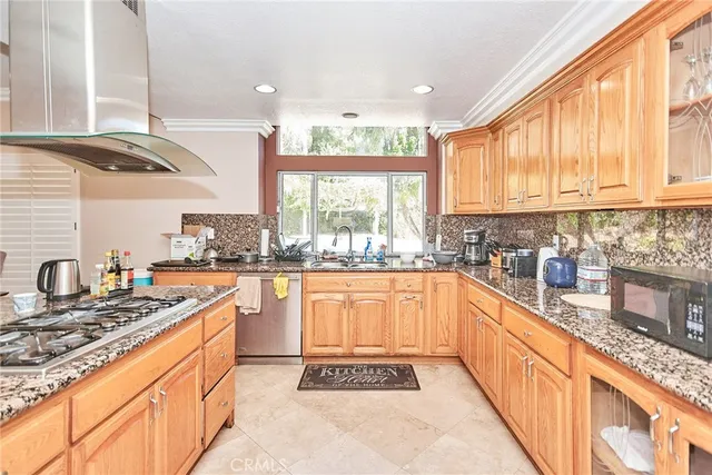 a kitchen with stainless steel appliances granite countertop a stove a sink and a microwave