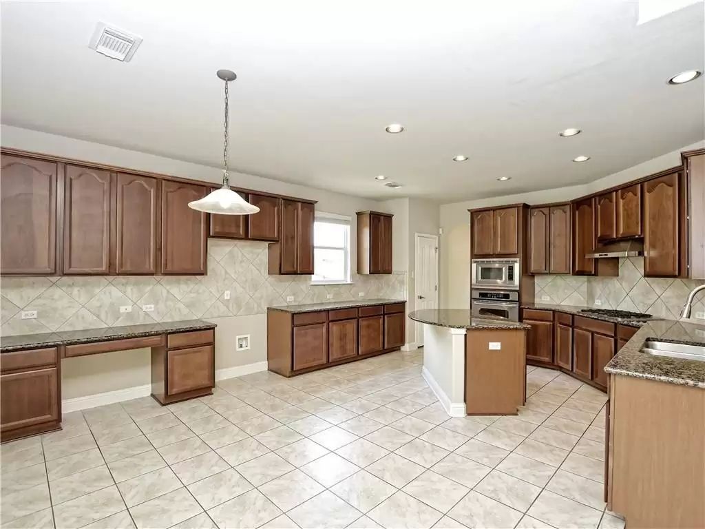 7005 Via Correto Drive Austin, TX 78749 - Photo 11 of 27 a kitchen with stainless steel appliances granite countertop a refrigerator a sink dishwasher a oven and a dining table with wooden floor
