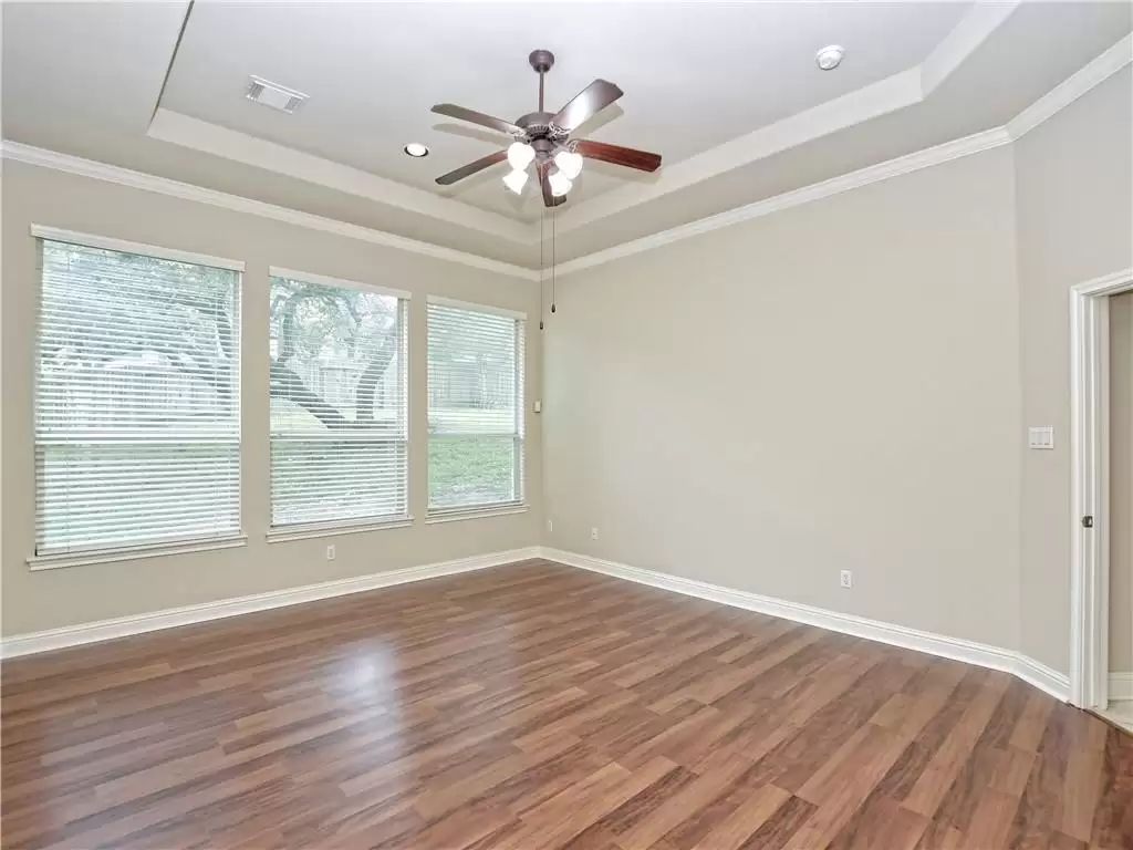 7005 Via Correto Drive Austin, TX 78749 - Photo 13 of 27 a view of an empty room with wooden floor and a window