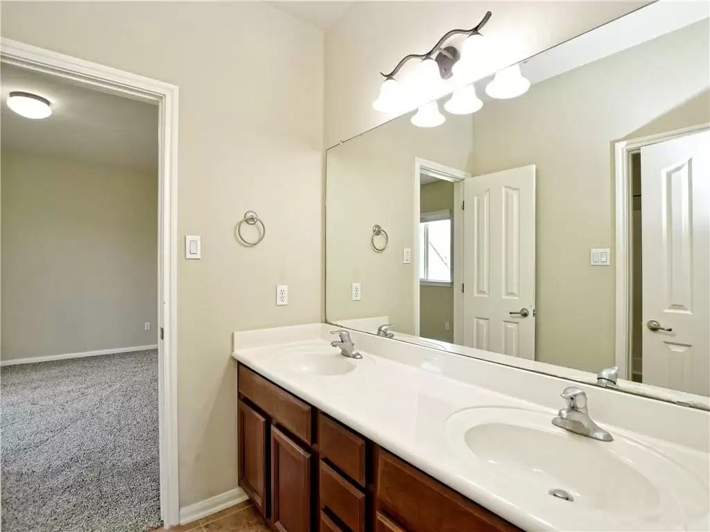 7005 Via Correto Drive Austin, TX 78749 - Photo 19 of 27 a bathroom with a double vanity sink and a mirror