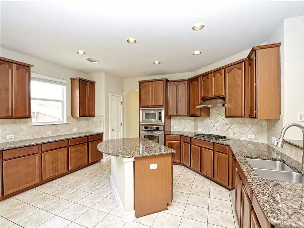 7005 Via Correto Drive Austin, TX 78749 - Photo 8 of 27 a large kitchen with granite countertop a sink and cabinets