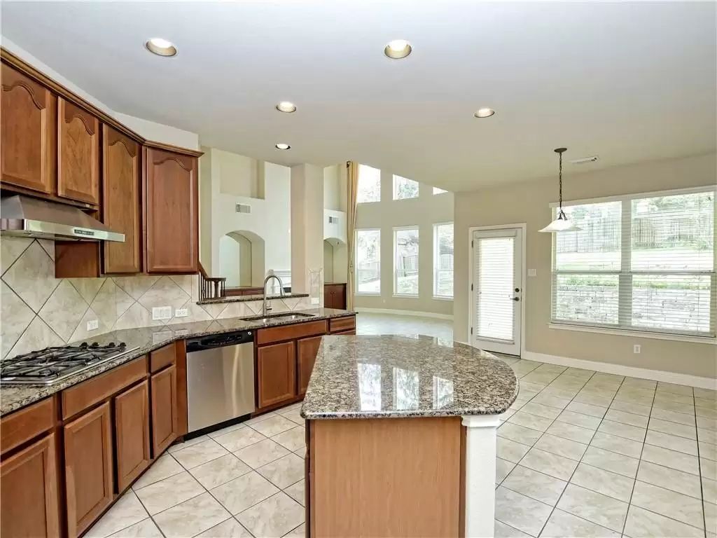 7005 Via Correto Drive Austin, TX 78749 - Photo 9 of 27 a large kitchen with granite countertop a sink and a stove