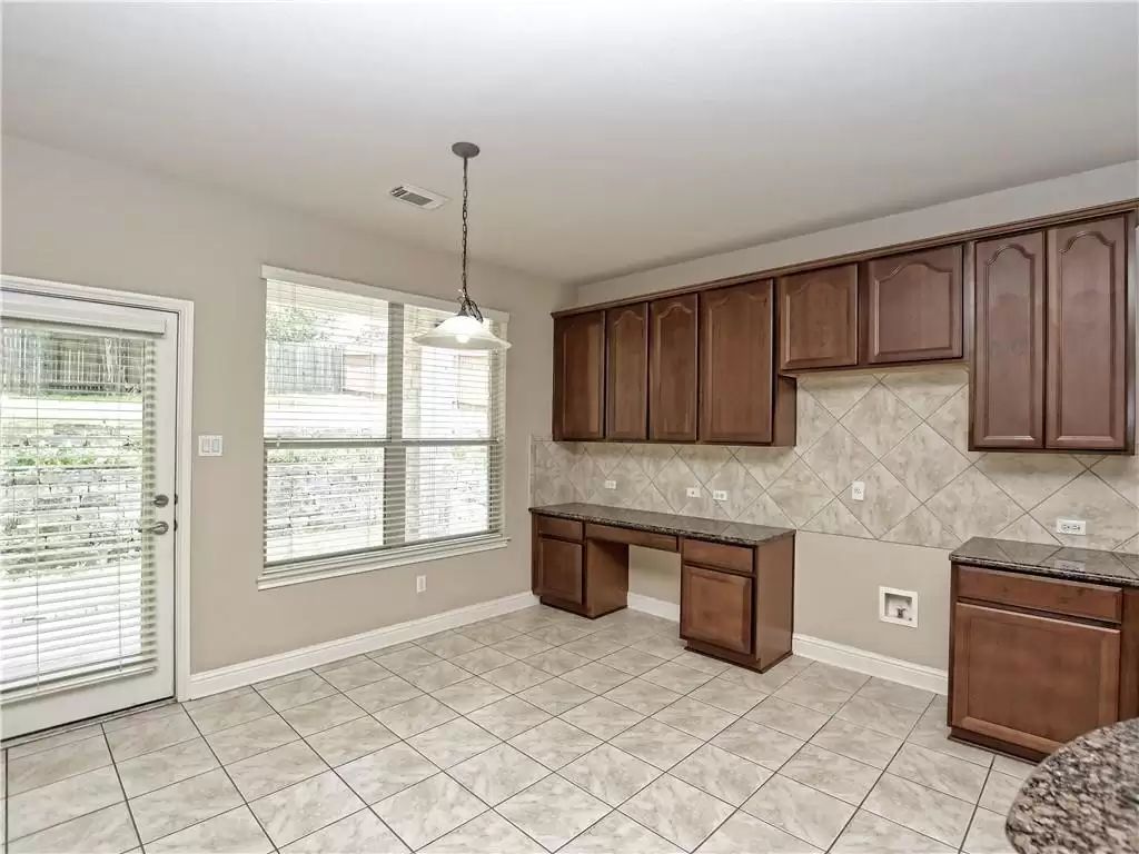 7005 Via Correto Drive Austin, TX 78749 - Photo 10 of 27 a kitchen with stainless steel appliances granite countertop a stove a sink and a microwave