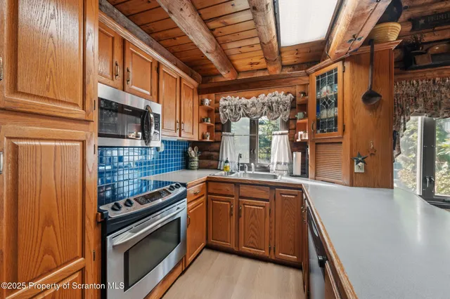 a view of a room with a large window and wooden floor