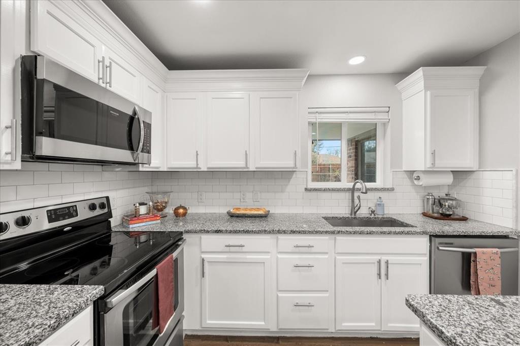 1405 Timberline Drive Benbrook, TX 76126 - Photo 7 of 26 a kitchen with granite countertop white cabinets stainless steel appliances and a counter space