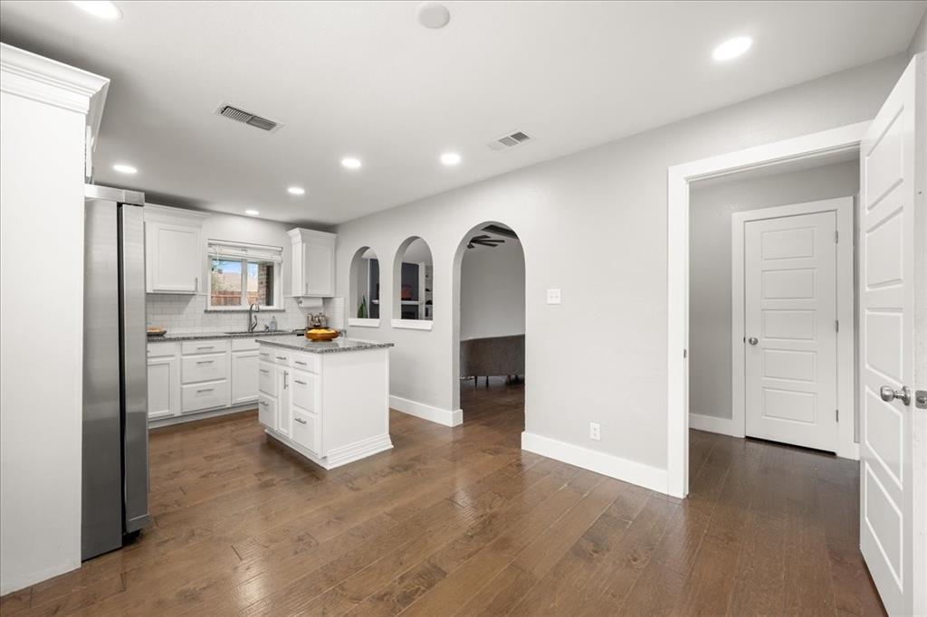 1405 Timberline Drive Benbrook, TX 76126 - Photo 9 of 26 a kitchen with white cabinets and stainless steel appliances