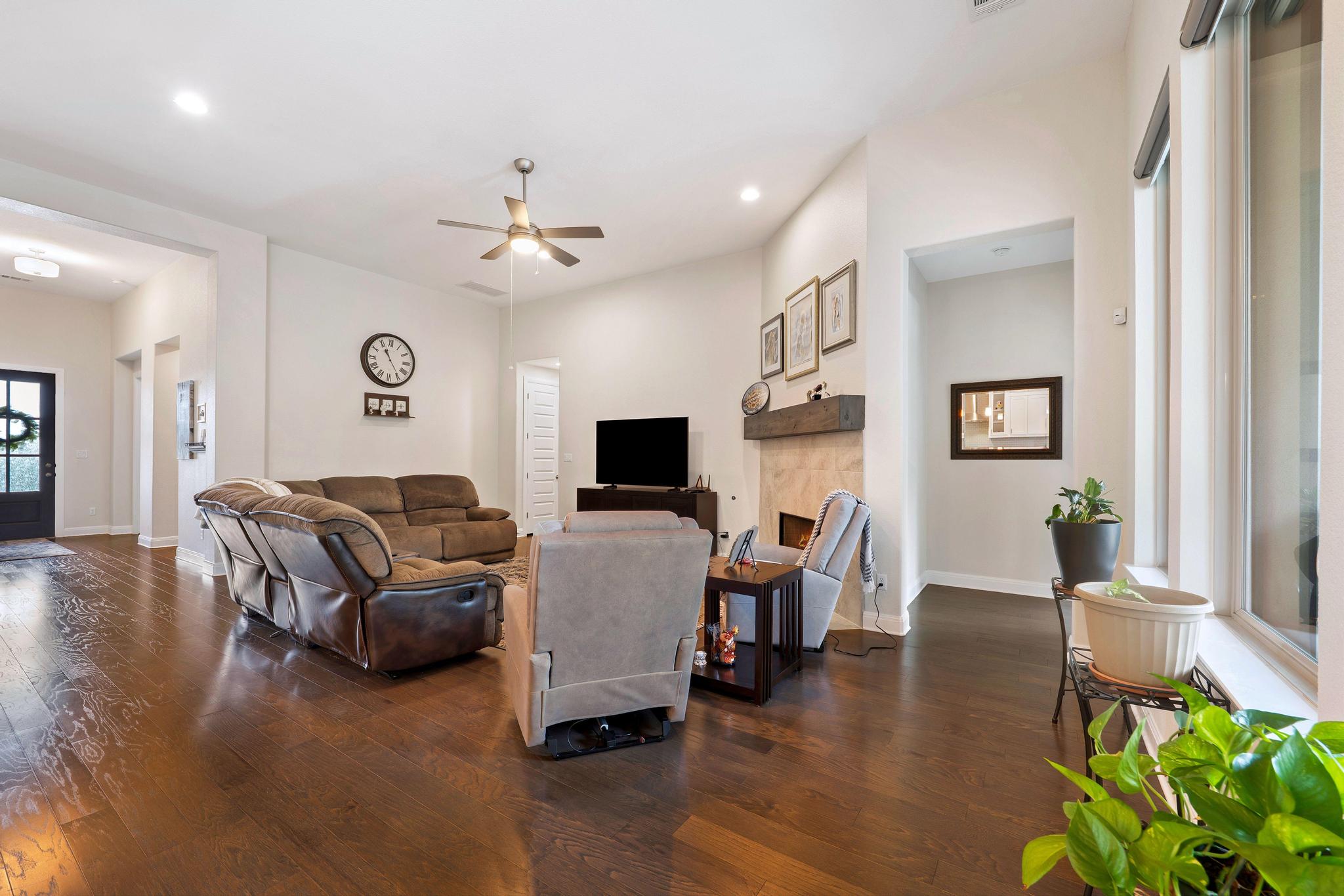 1009 Legacy Crossing Georgetown, TX 78628 - Photo 11 of 40 Rich hardwood floors complement this spacious living area, highlighted by a cozy fireplace and high ceilings.