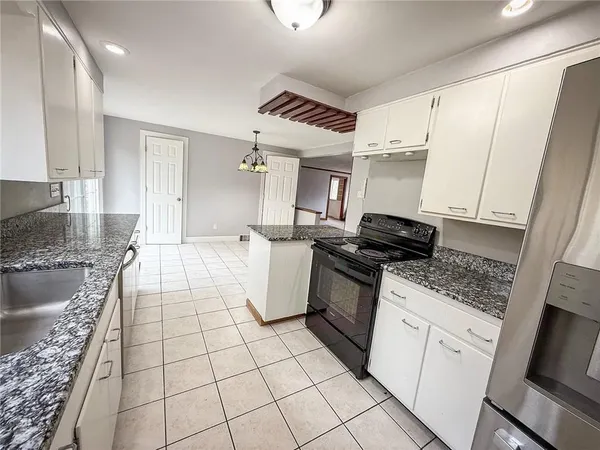 a kitchen with stainless steel appliances granite countertop a sink stove and cabinets