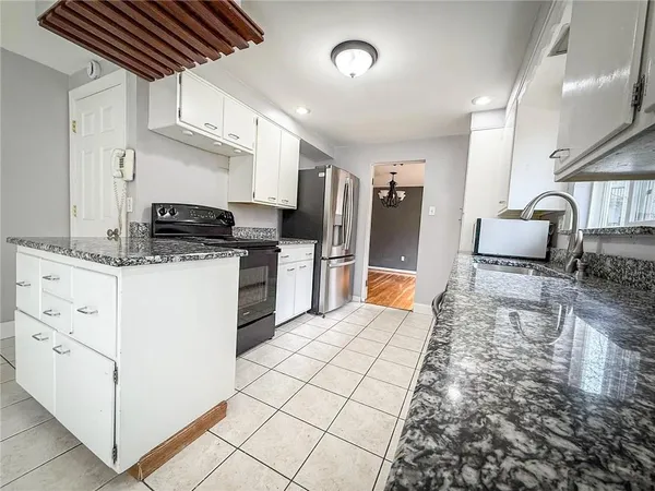 a large white kitchen with cabinets