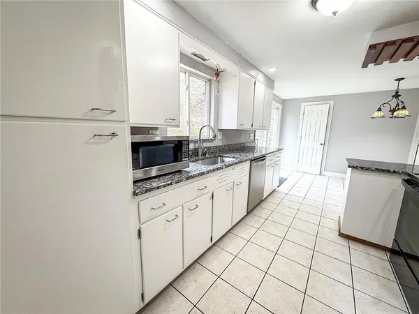 a kitchen with stainless steel appliances a sink and a refrigerator