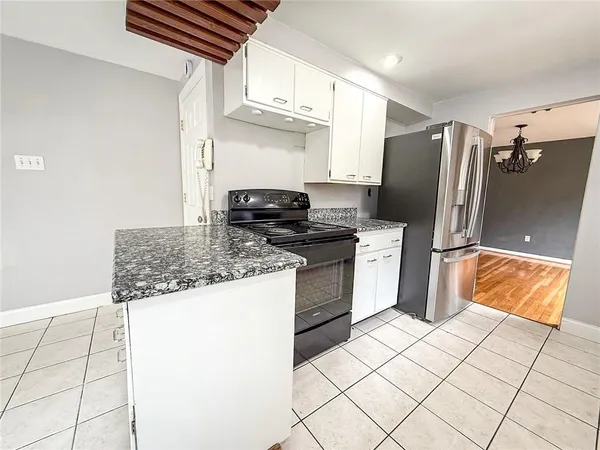a kitchen with stainless steel appliances granite countertop a refrigerator a stove and a sink