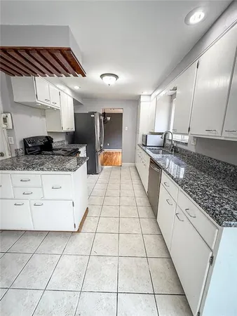 a large kitchen with stainless steel appliances granite countertop a stove a sink and a granite counter tops