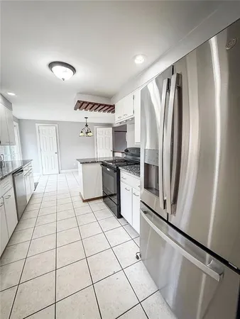 a kitchen with stainless steel appliances a refrigerator sink and cabinets
