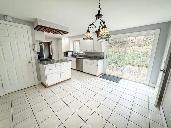 a kitchen with stainless steel appliances granite countertop a stove a sink and white cabinets