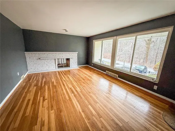 a bed sitting in a spacious bedroom next to a window