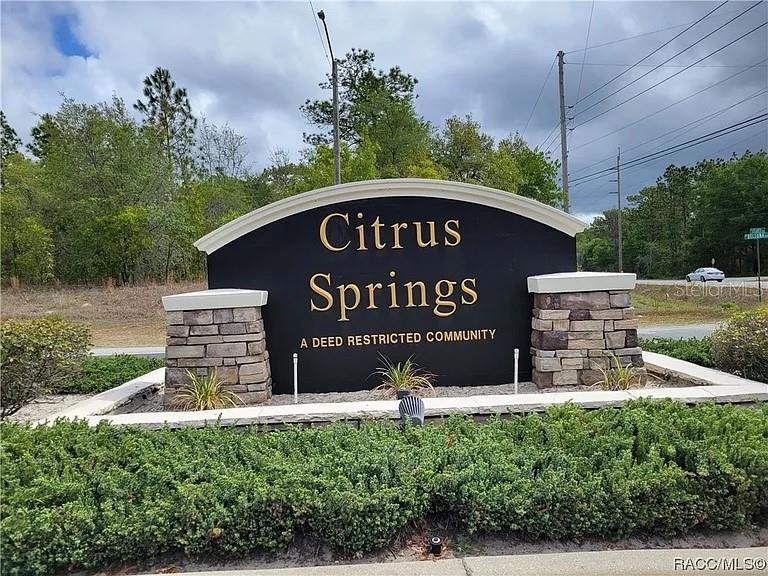 7866 North Manville Road Citrus Springs, FL 34434 - Photo 18 of 19 a sign board with a house and a yard in the background
